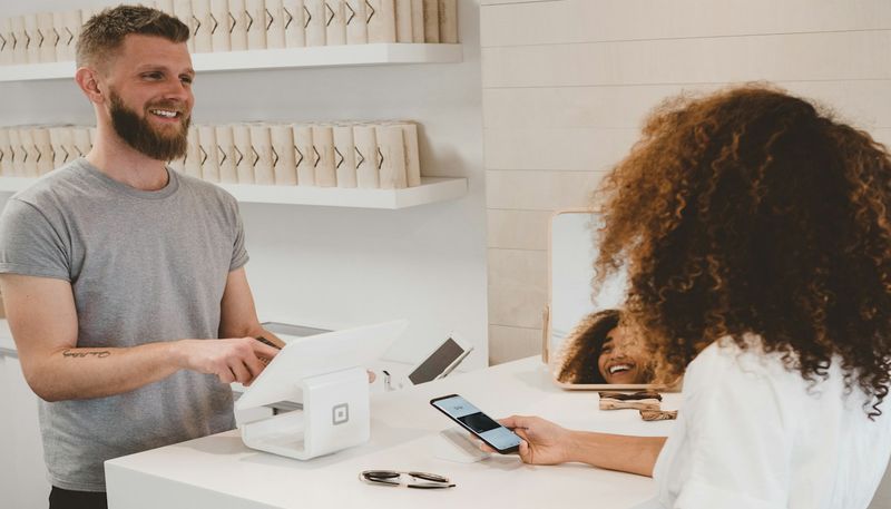 Persona che confronta cataloghi prodotto su schermo per scegliere una piattaforma e-commerce